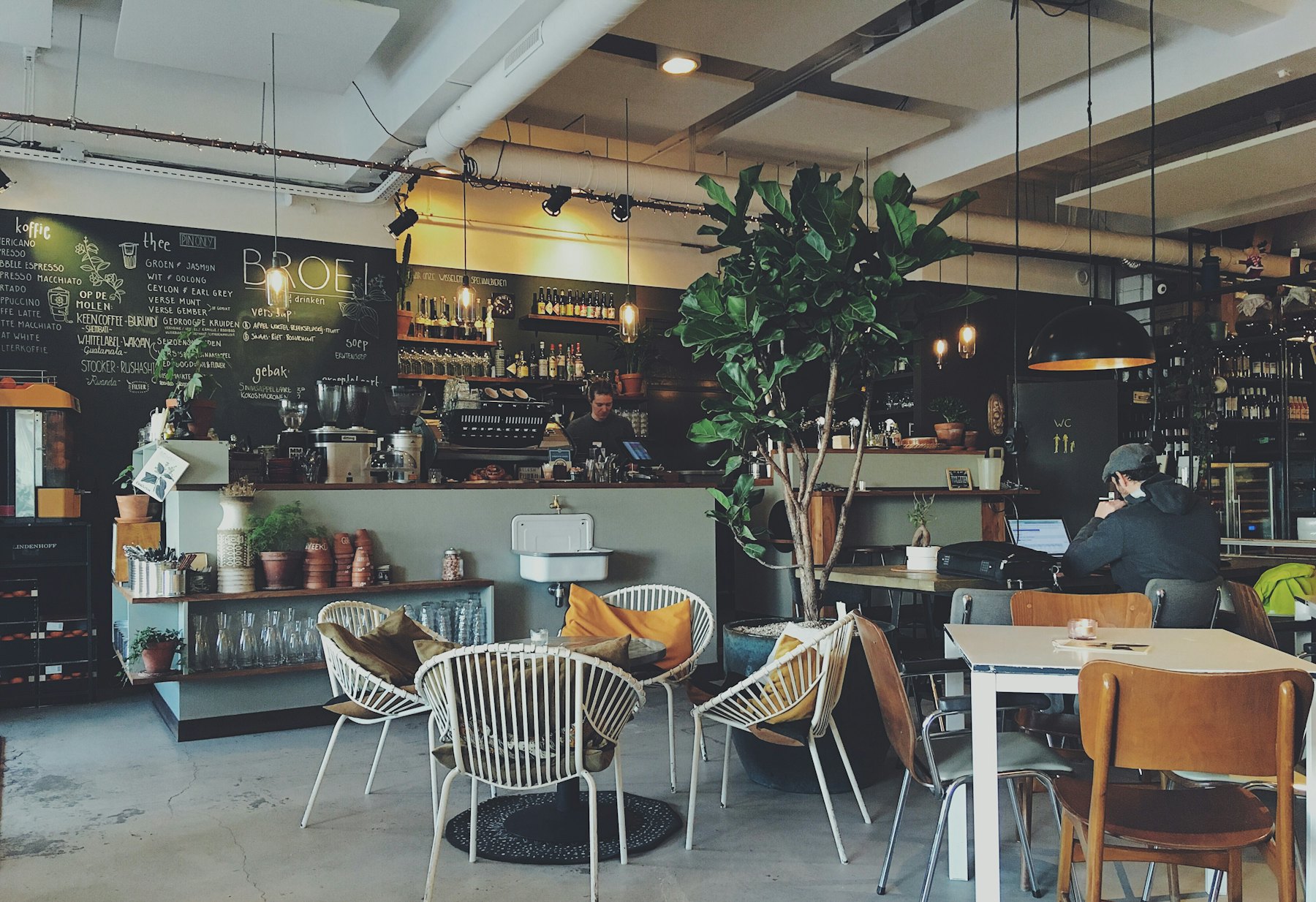 A quiet, sunlit café with empty wooden tables